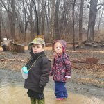 children in forest puddle